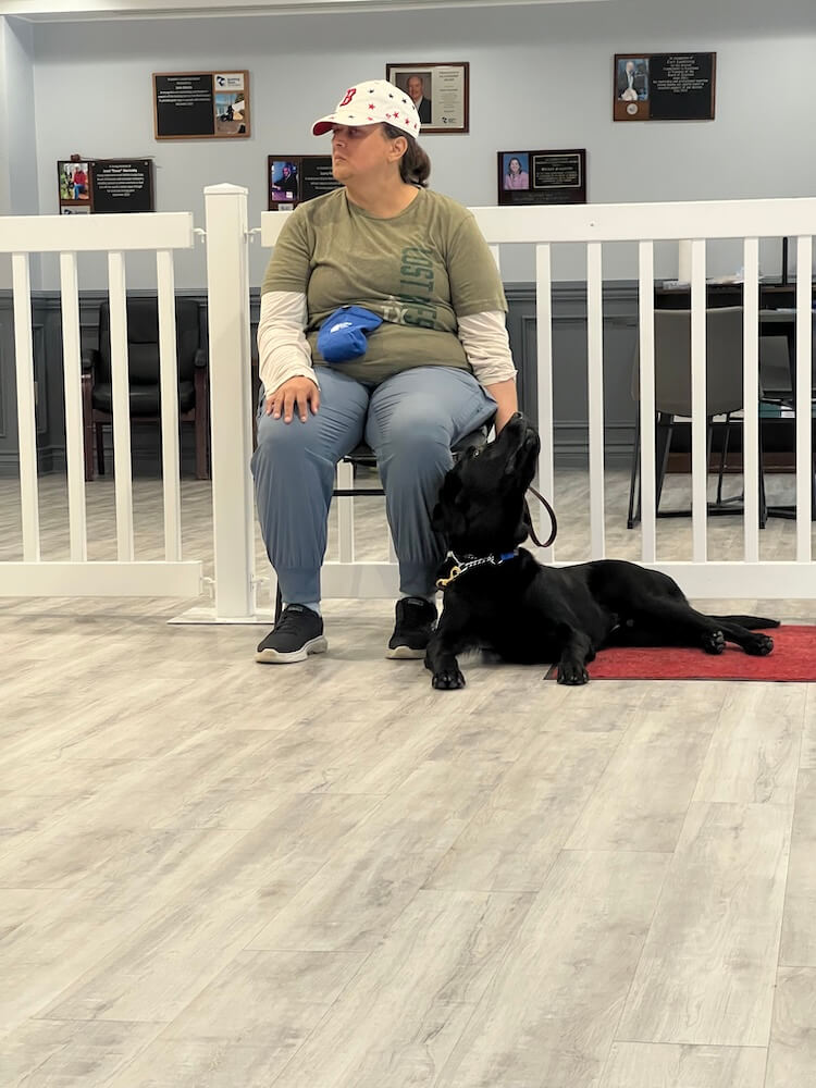 Rachel sits in Alumni Hall during indoor training as Vic lies against her leg