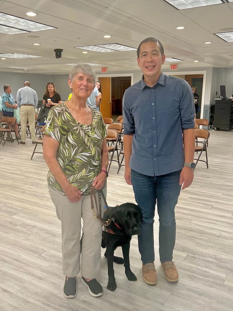 graduate Robin stands beside Yacht and her puppy raiser David, after graduation