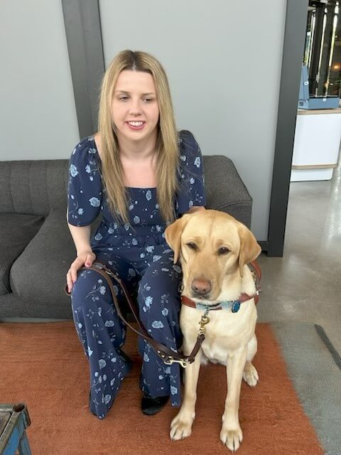 Morgayne and yellow guide dog Omega (Nala) sit together for a team portrait