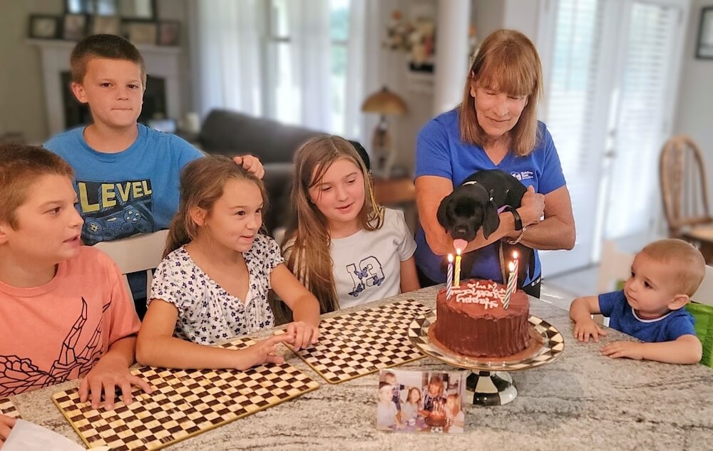 First day at raiser's home Mimi eyes a birthday cake in honor of her namesake with grandkids present