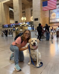 Donna and adopted GEB yellow Lab Yarmouth pose in NYC's Grand Central