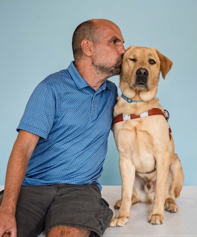 While sitting for their team portrait, Jim turns to kiss Keanu on the head and Keanu closes his eye to receive it