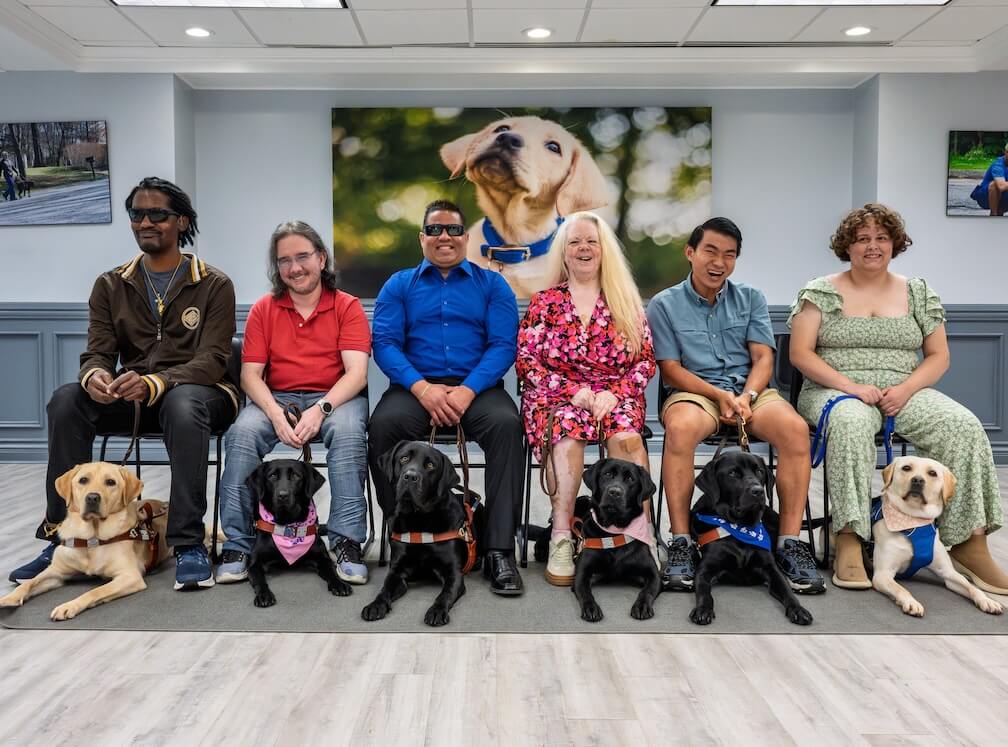 class photo of July 28 2026 class with handlers sitting in a row and guides at their feet