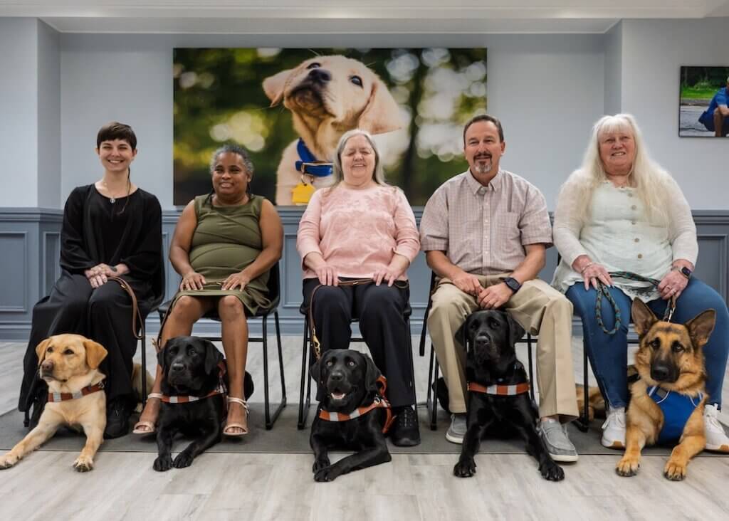 Class portrait for Sept 1, 2026 class, sitting in a row with guide dogs at their feet