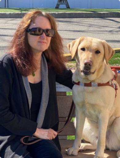 woman with yellow lab guide sitting on bench